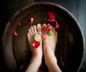 Feet soaking in water with petals