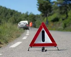 broken down car with a warning triangle to the forefront