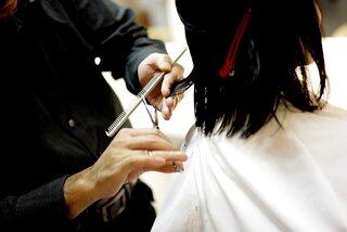 hairdresser cutting hair using scissors and comb