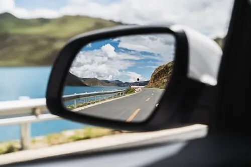 View of mountains in car wing mirror