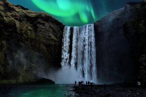 northern lights over waterfall