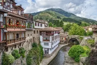 buildings by river with bridge