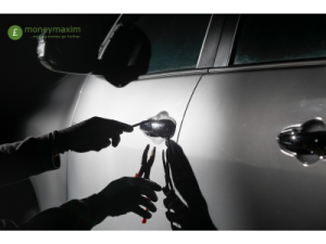 thief using tools to break into a car door at night