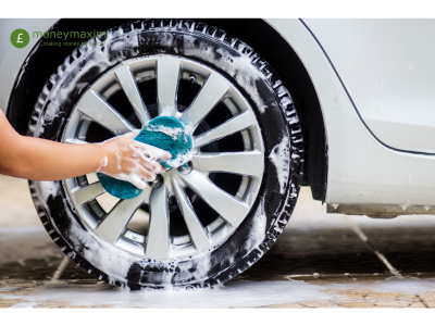 a car wheel being cleaned by hand with a blue sponge