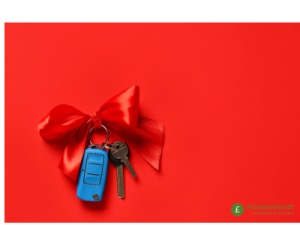 blue key fob tied with red ribbon on red background